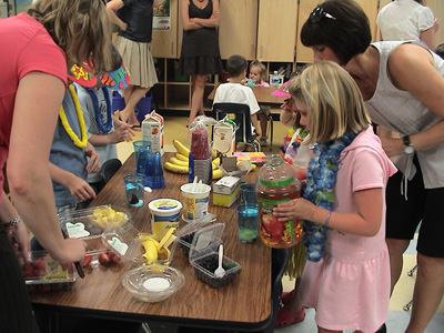 Emma making a drink with fruit at the party